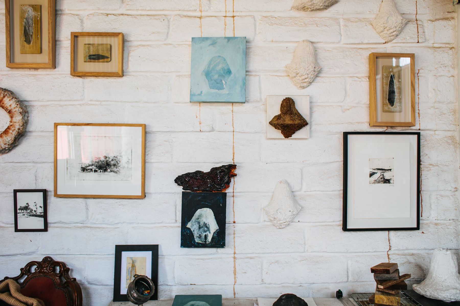 Eclectic retail-style gallery wall with framed and sculptural wall art in varied sizes