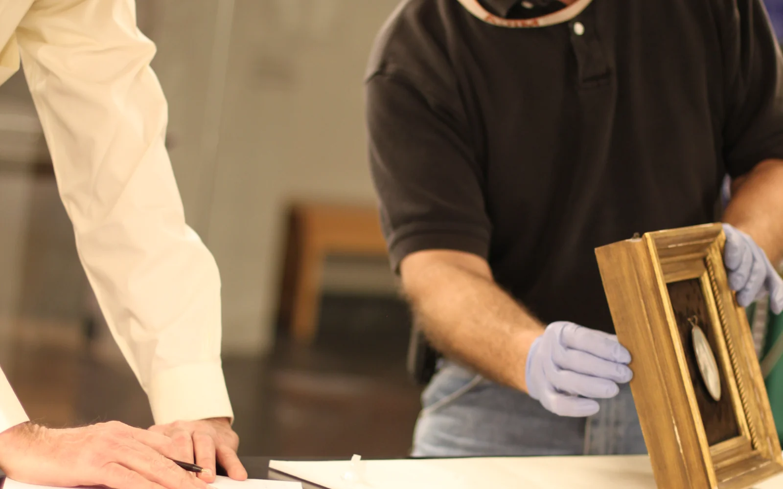 Frame conservator examining a picture frame during a consultation