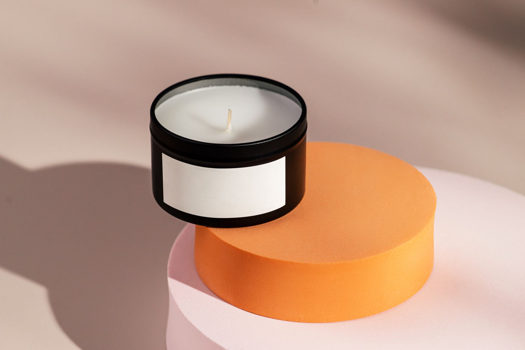 Black candle jar with a blank front label on a product photography set