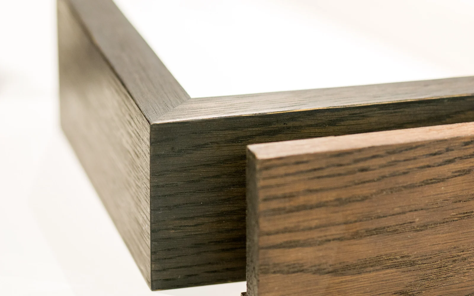 Close view of walnut picture frame profile chevrons showing different sections and finishes