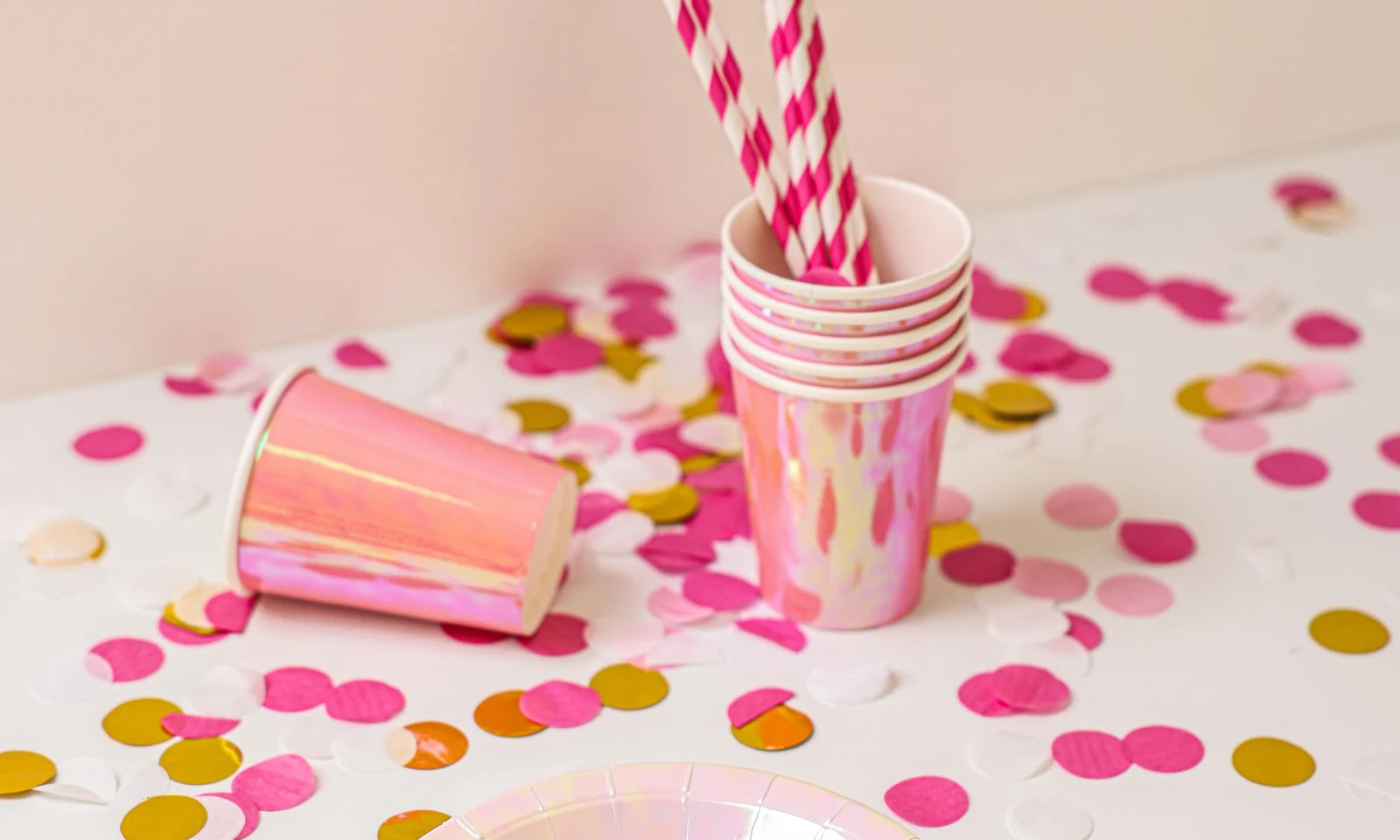 Disposable paper cups, plates and straws arranged in a party setting