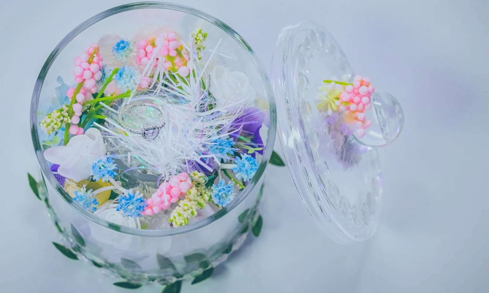 Artificial floral arrangement displayed as a table centrepiece in a glass bowl