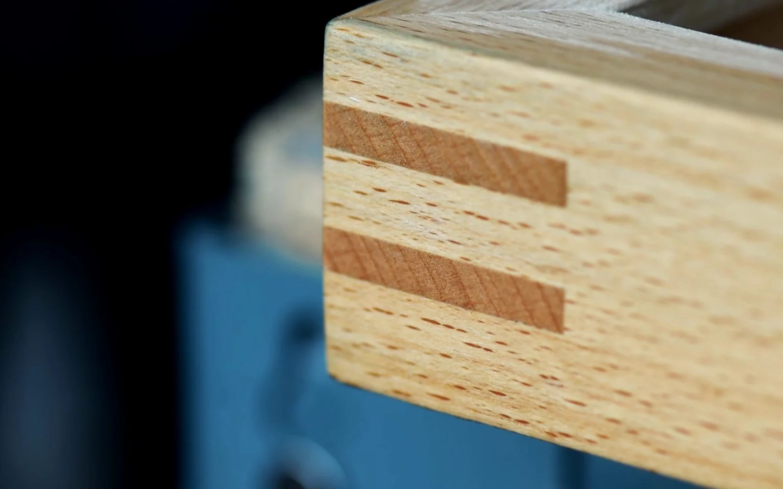 Close-up of a wooden box picture frame corner reinforced with contrasting splines