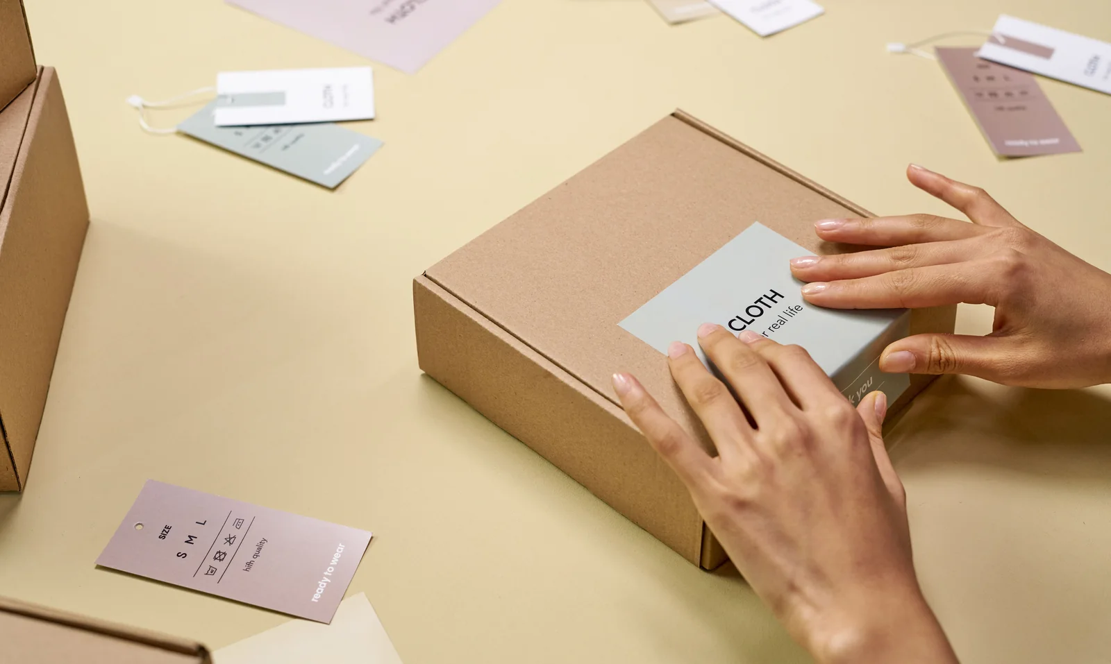 Hands applying a printed label to a product box during packing