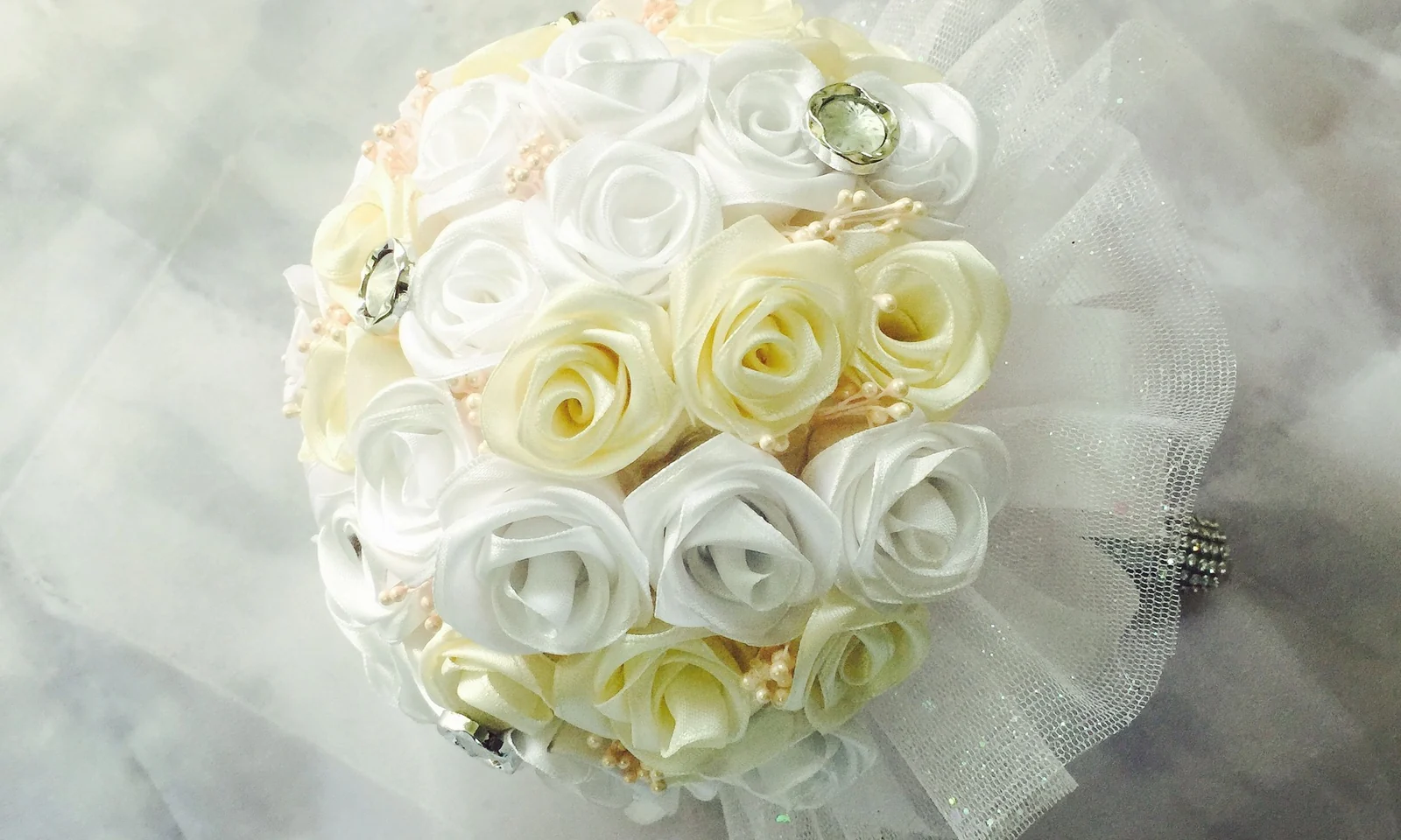 White and cream artificial wedding bouquet with layered rose heads and decorative details