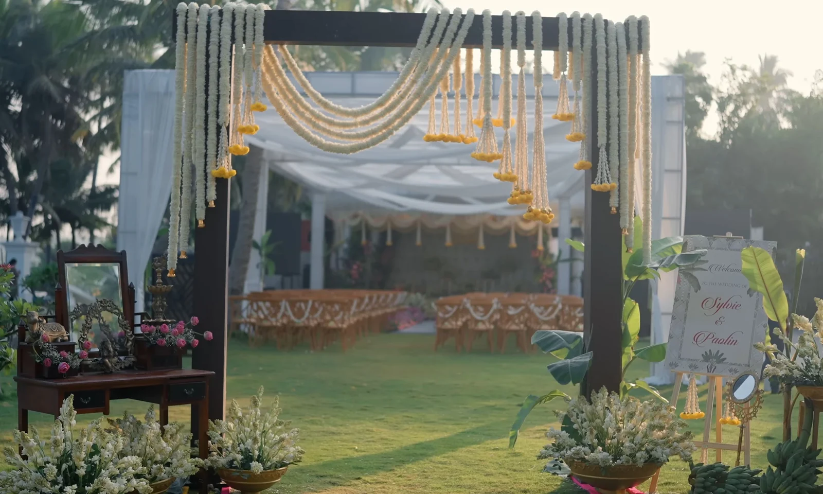 Outdoor wedding ceremony venue with floral decor, arch and guest seating